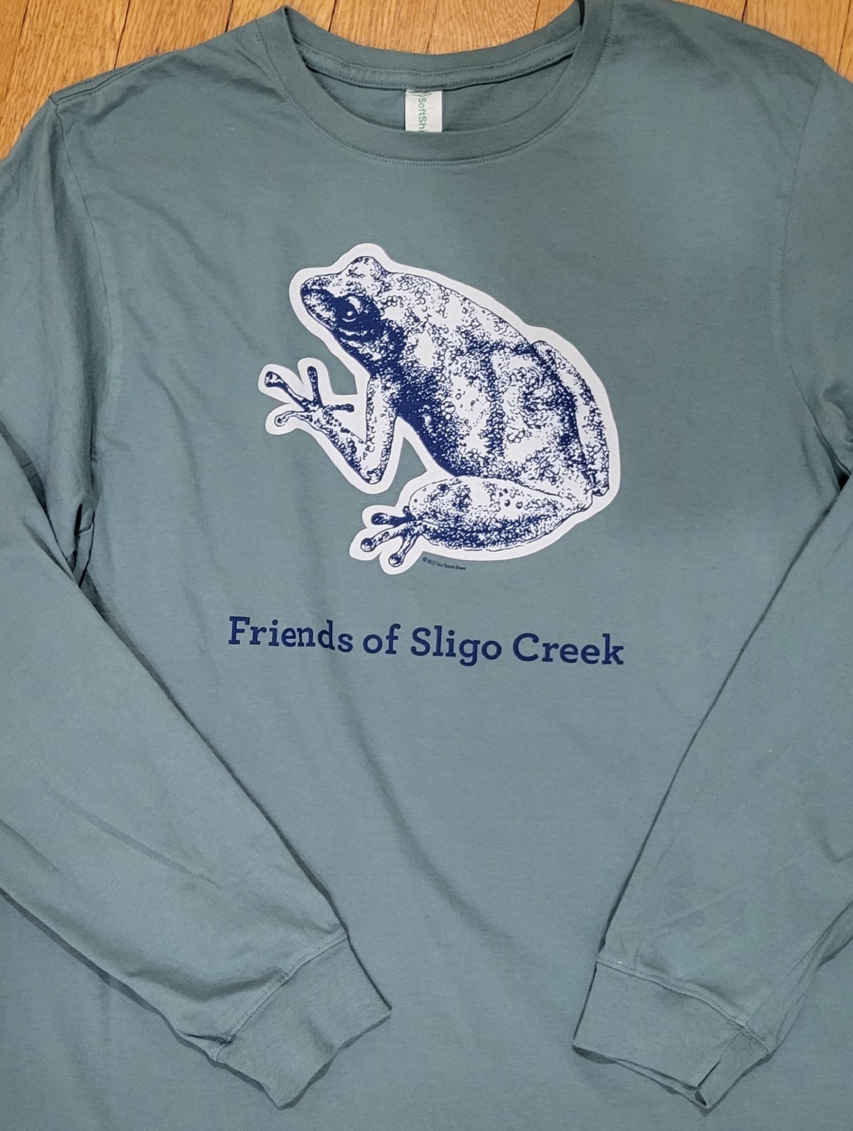 The FOSC long sleeved t-shirt in pine green with a drawing of a frog on the front.